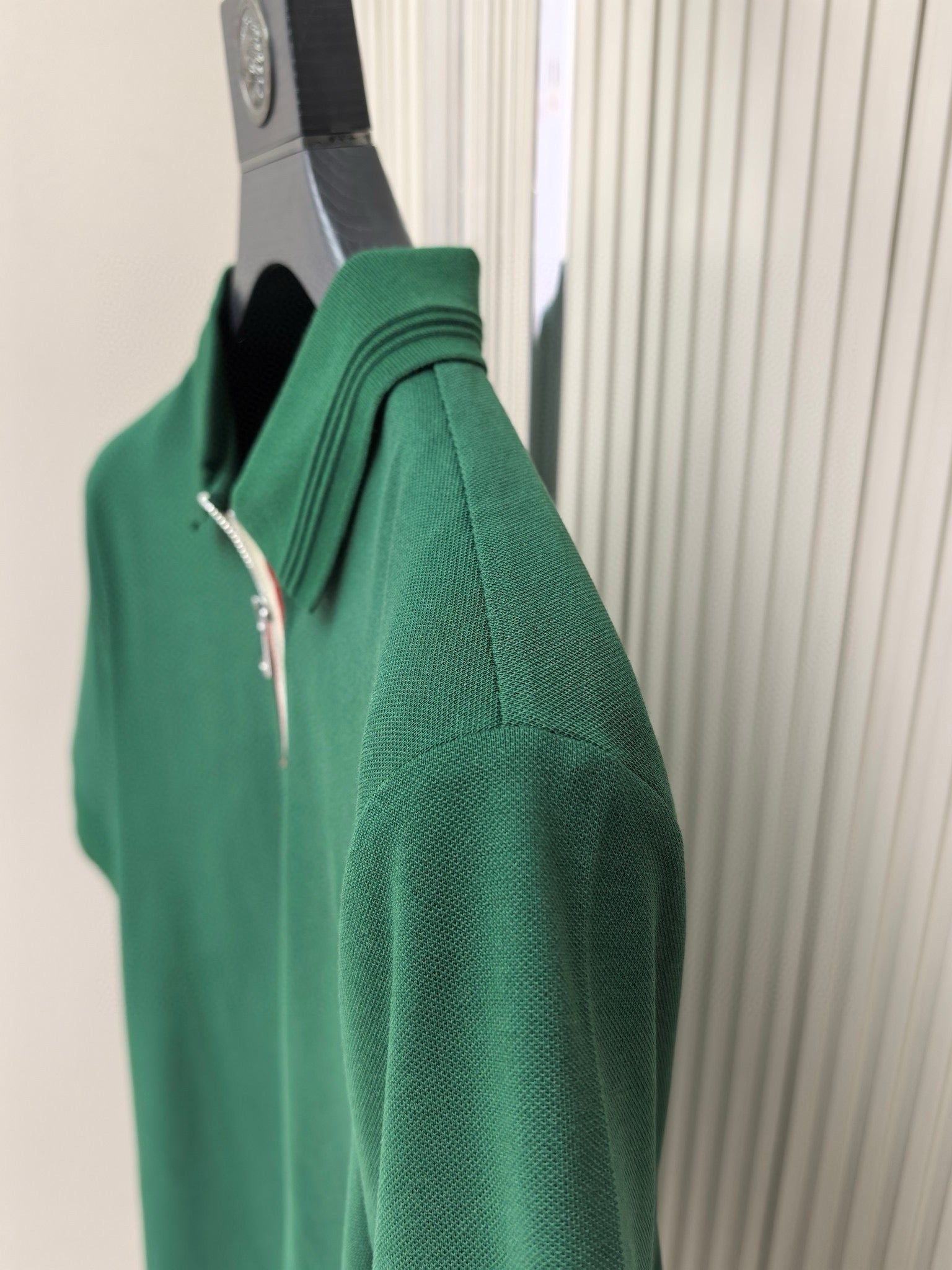 Green polo shirt side view with short sleeves and seam detail