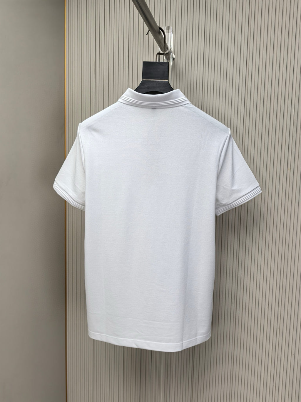 White short-sleeve polo shirt back view with ribbed collar and clean straight hem.