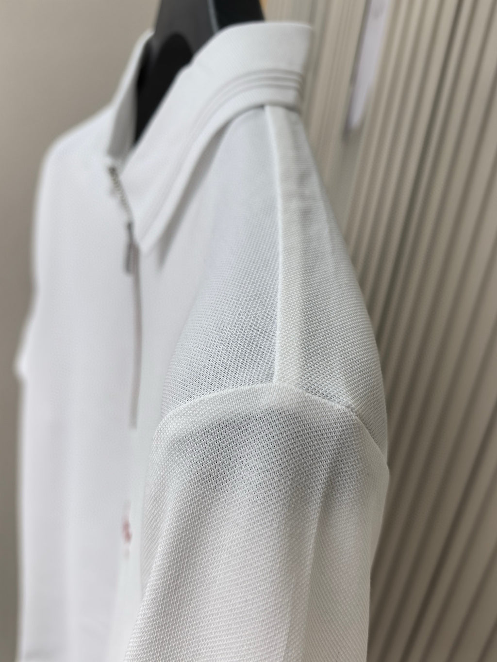 White polo shirt shoulder seam close-up with textured fabric