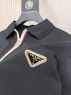 Black polo shirt close-up of Prada logo patch on chest