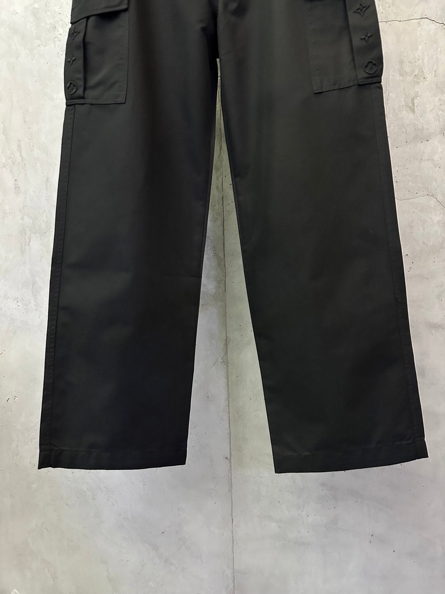 Black cargo pants with straight wide legs and stitched hem
