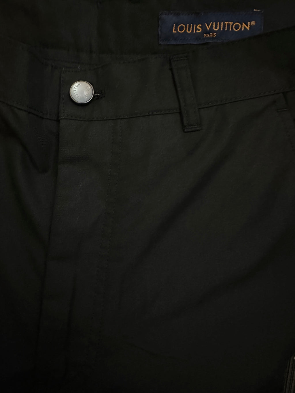 Black pants waistband with Louis Vuitton label and metal button closure