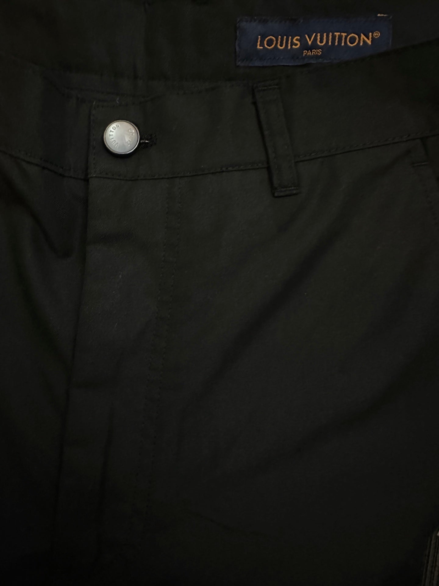 Black pants waistband with Louis Vuitton label and metal button closure