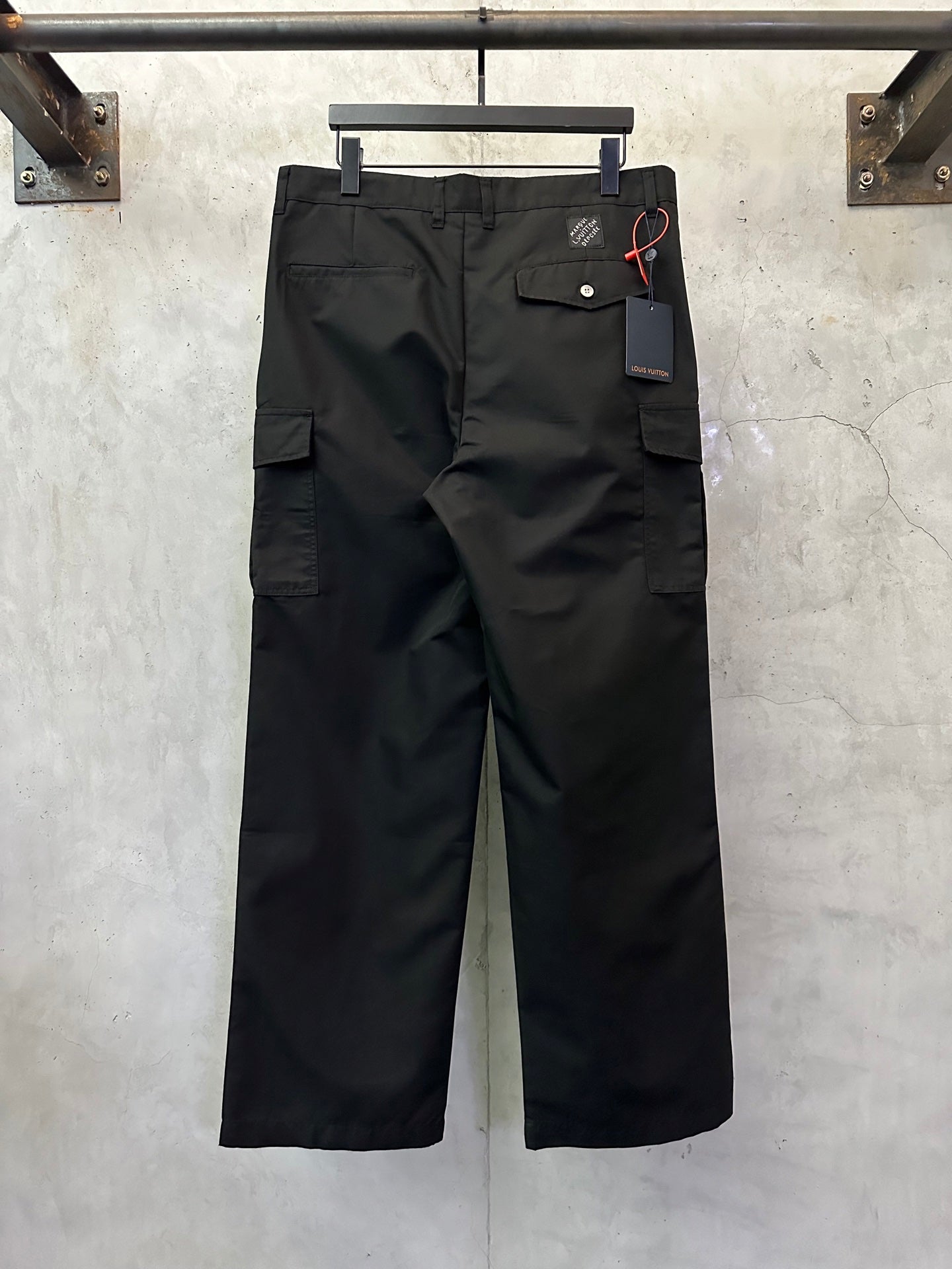 Black cargo pants front view with cargo pockets and hanging price tag