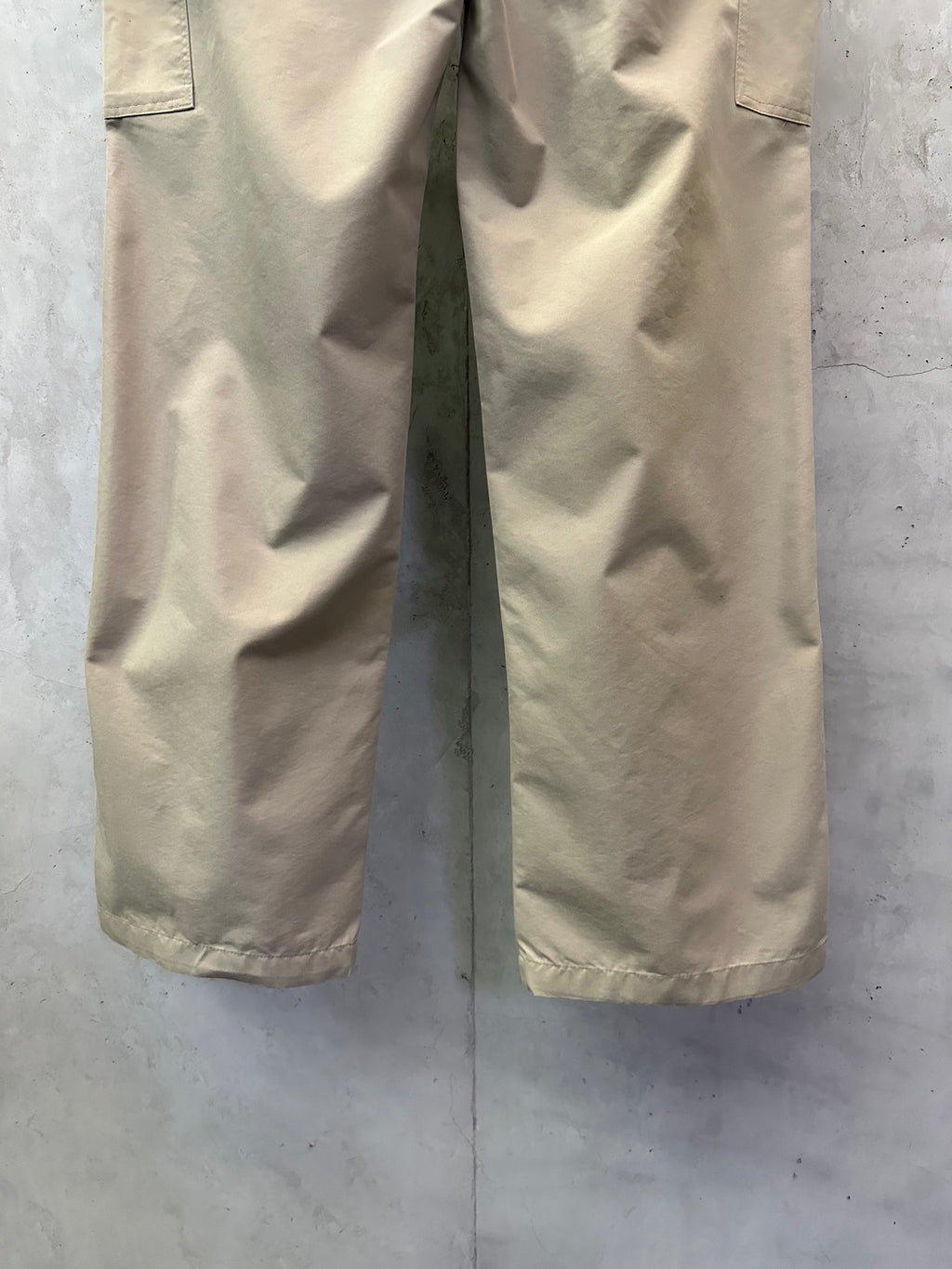 Beige cargo pants with creased fabric and straight cut legs