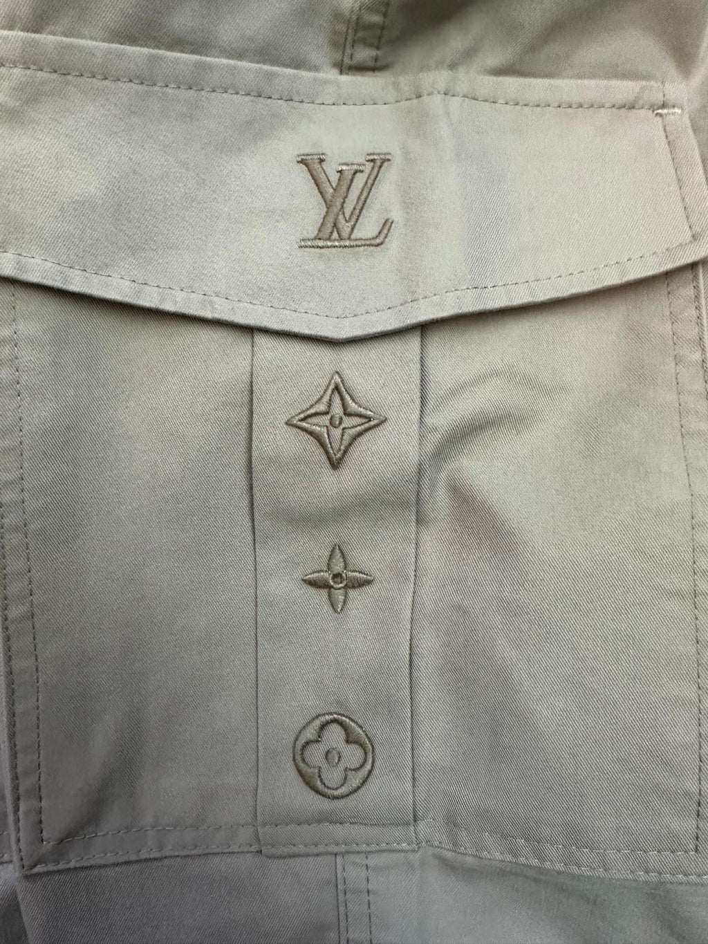 Beige pants button placket with Louis Vuitton monogram and star emblems