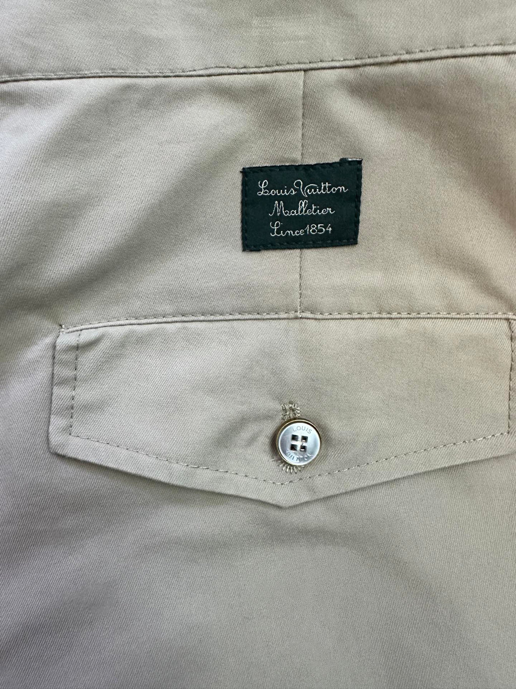 Beige pants waistband with Louis Vuitton Material tag and button