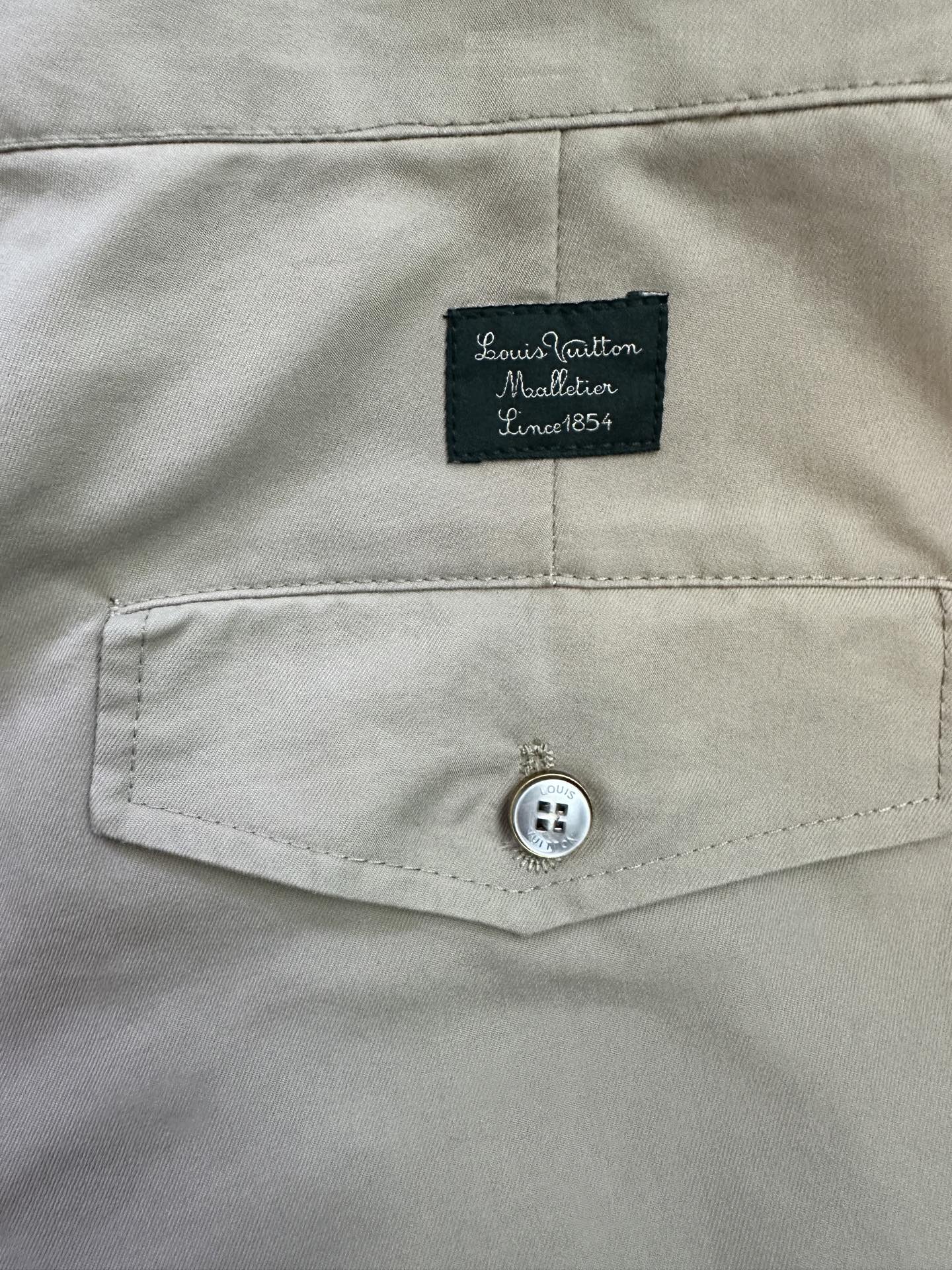Beige pants waistband with Louis Vuitton Material tag and button