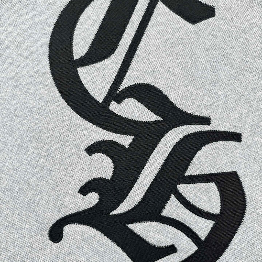Close-up of black and white logo graphic on heather gray sweatshirt
