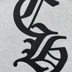 Close-up of black and white logo graphic on heather gray sweatshirt