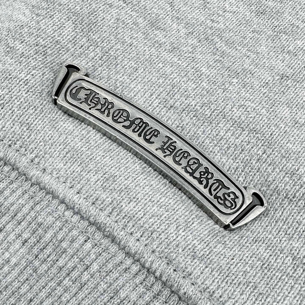 Chrome Hearts-branded metal neck label on heather gray sweatshirt seam