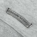 Chrome Hearts-branded metal neck label on heather gray sweatshirt seam
