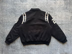 Black varsity jacket back view with white sleeve stripes and small logo patch