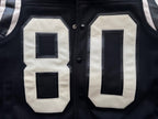 Black varsity jacket front close-up with appliqué “80” panels in white and dark