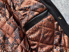 Snake-print quilted lining with black trim panel inside a black varsity jacket