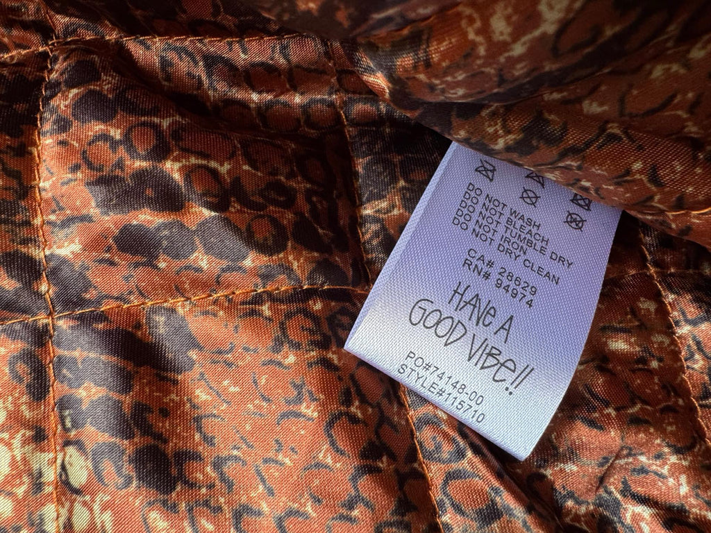 Orange-brown snake-print lining with white size and care label tag