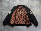 Black varsity jacket open front with orange-and-brown snake-print lining