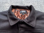Black varsity jacket collar with orange-and-brown snake-print lining and brand label