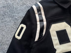 Black varsity jacket sleeve with white stripe and white appliqué “0” patch