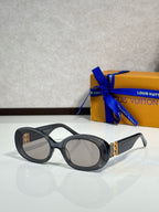 Black oval sunglasses with dark lenses and gold LV logo on temple