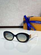 Black oval sunglasses with pale lenses and gold LV logo on temple