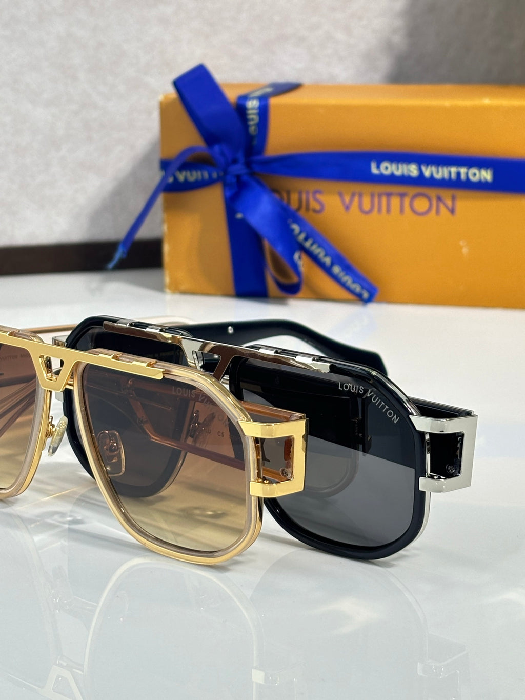 Louis Vuitton sunglasses in black and gold with dark lenses, close side view