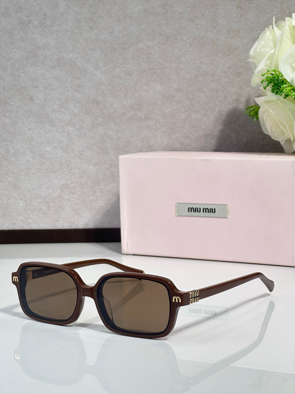 MiuMiu sunglasses with brown frames and dark tinted lenses