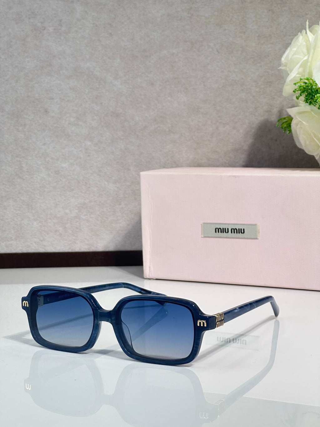 MiuMiu sunglasses with deep blue frames and blue tinted lenses
