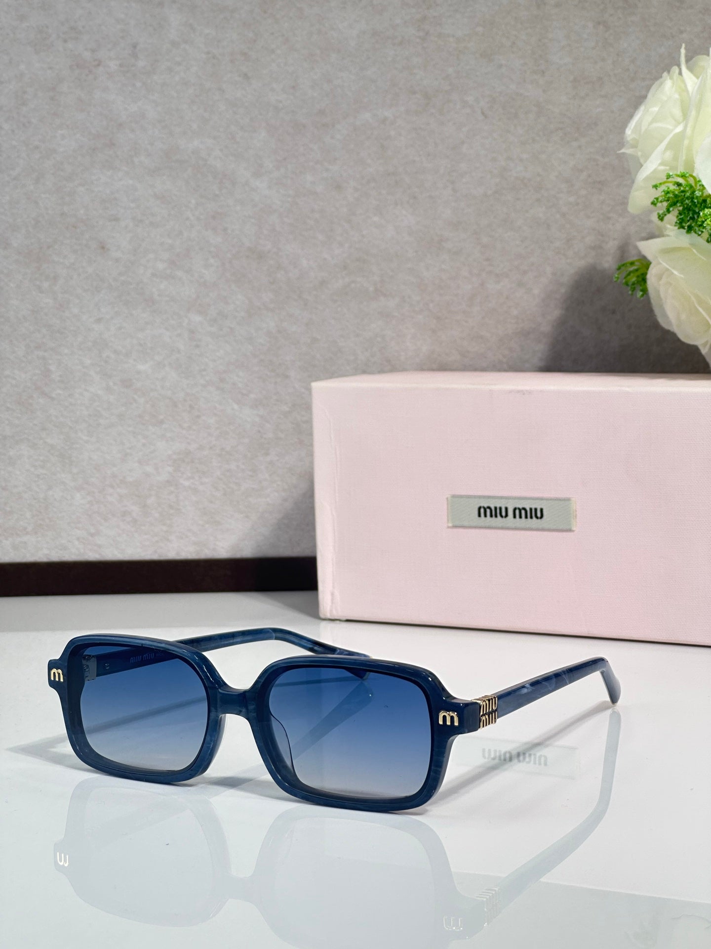 MiuMiu sunglasses with deep blue frames and blue tinted lenses