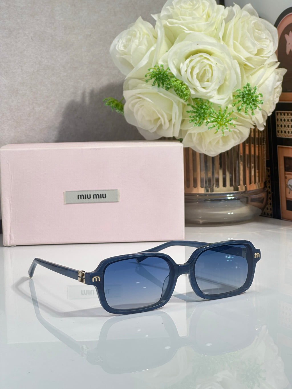 MiuMiu sunglasses with blue frames and blue tinted lenses