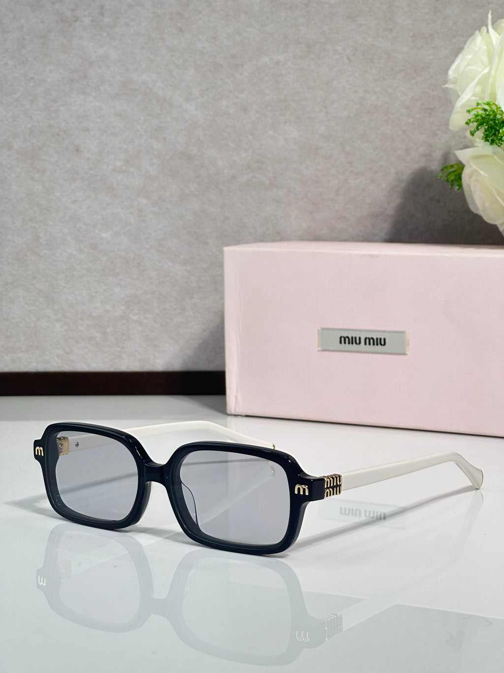 MiuMiu sunglasses with navy-blue frames and clear-to-tinted lenses