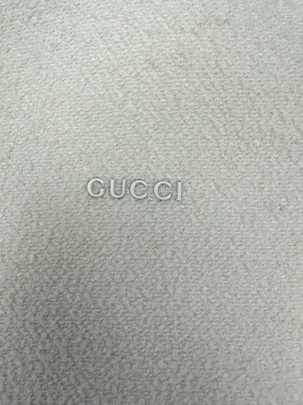 Off-white hoodie fabric with GUCCI logo text