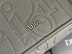Dior men's bag close-up of embossed logo on grained leather surface