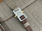 Dior bag keychain attachment on light gray strap hardware with brown webbing