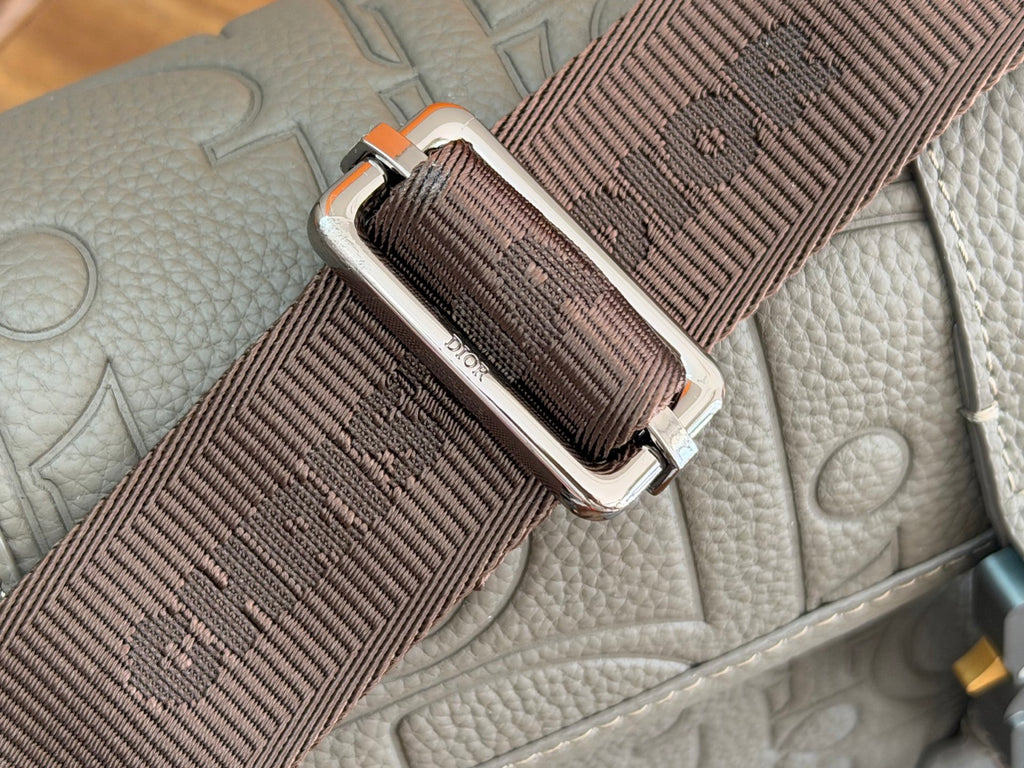 Dior men's bag strap close-up with metal buckle and woven webbing