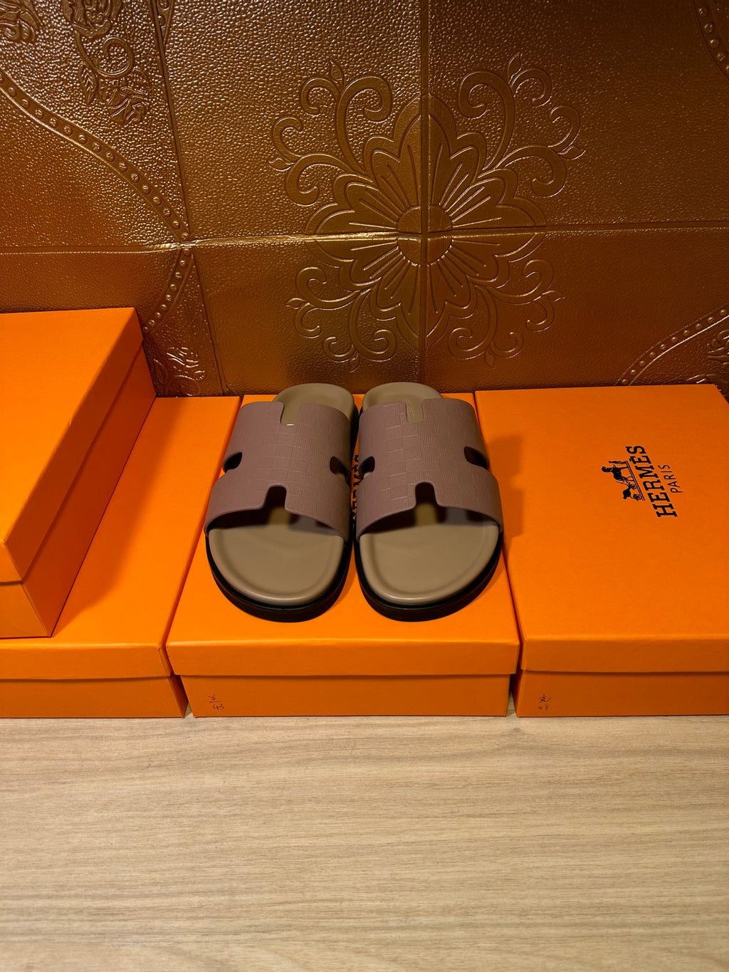 Hermes slide sandals pair on orange boxes, lilac straps and beige base
