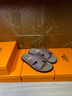Hermes slide sandals on orange boxes, lilac straps and beige footbed