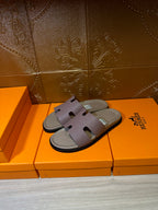 Hermes slide sandals on orange boxes, lilac straps with black rubber sole