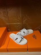 Hermes white slide sandals with smooth straps and cutout H-style detail