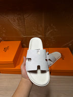 Hermes white slide sandals with textured straps and molded footbed, heel side