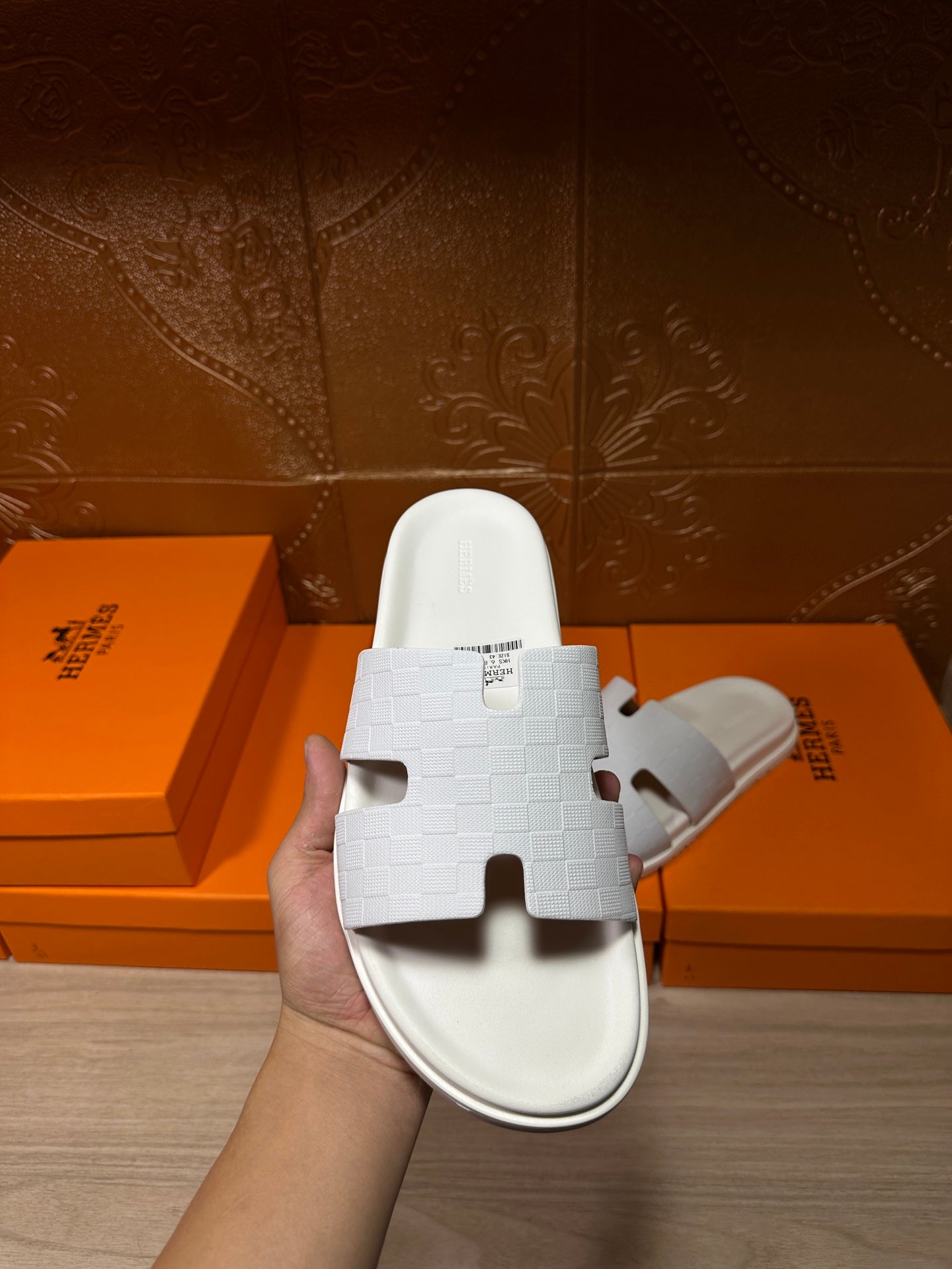 Hermes white slide sandals with textured straps and molded footbed, heel side