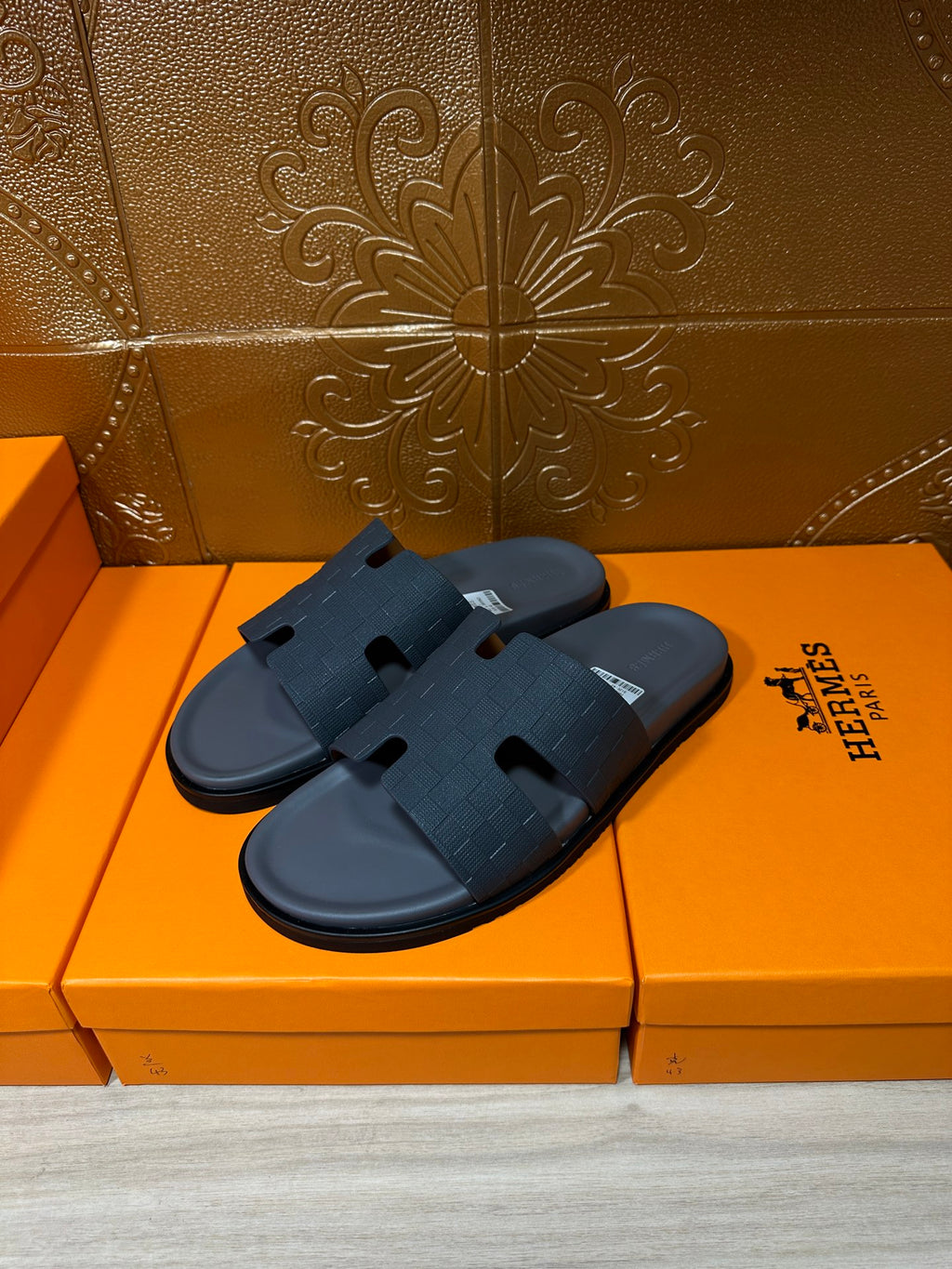 Pair of dark blue slide sandals with open toe and textured cross strap