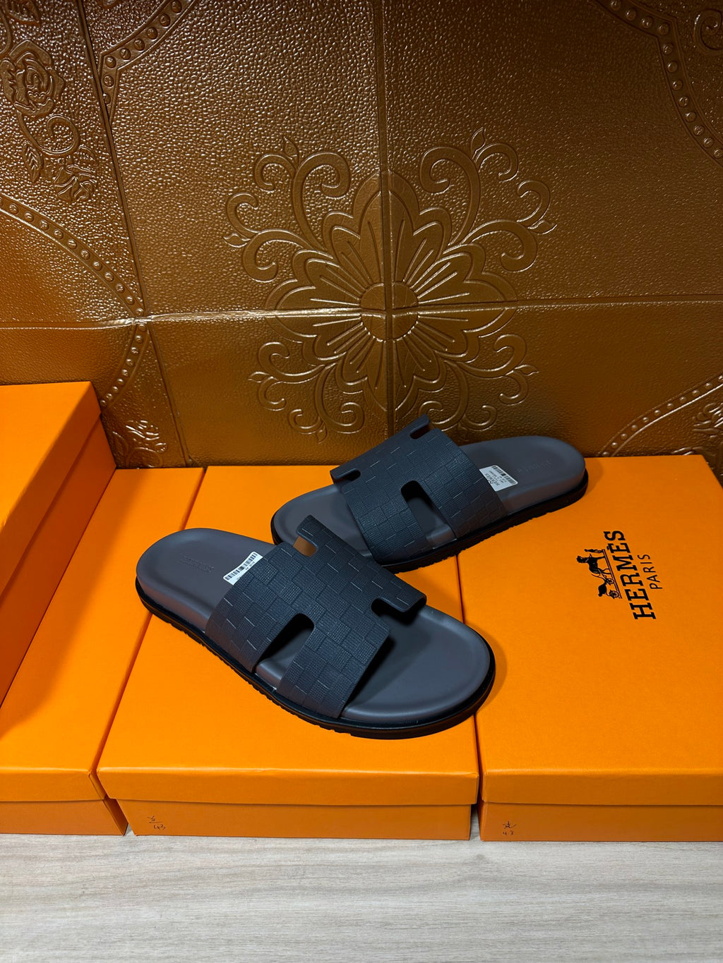 Dark blue slide sandals on shoeboxes, open toe with textured cross strap