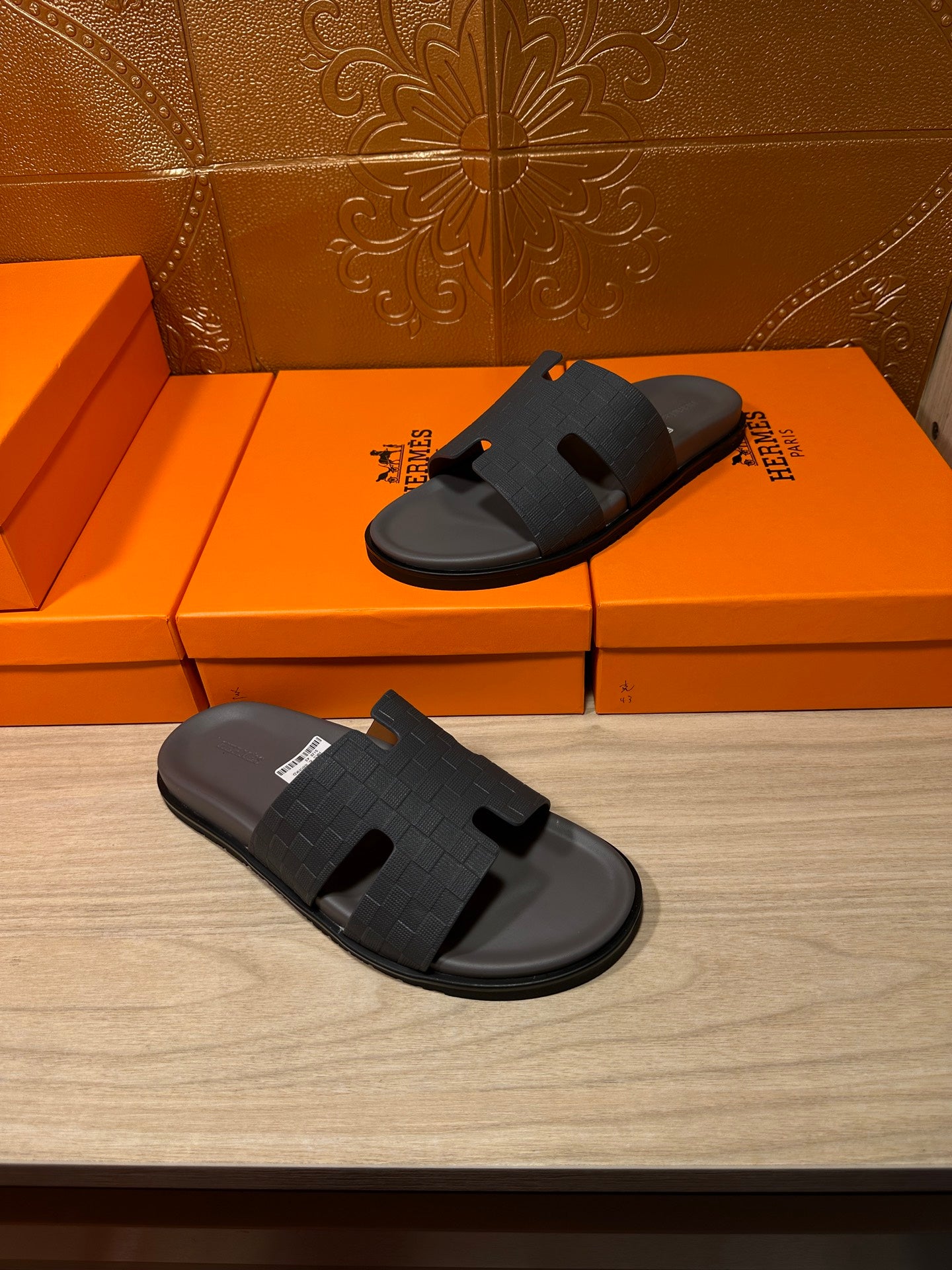 Dark blue slide sandals on shoeboxes, open toe with textured cross strap