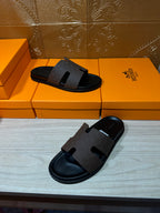 Hermes slide sandals with dark wide strap and open toe, front view