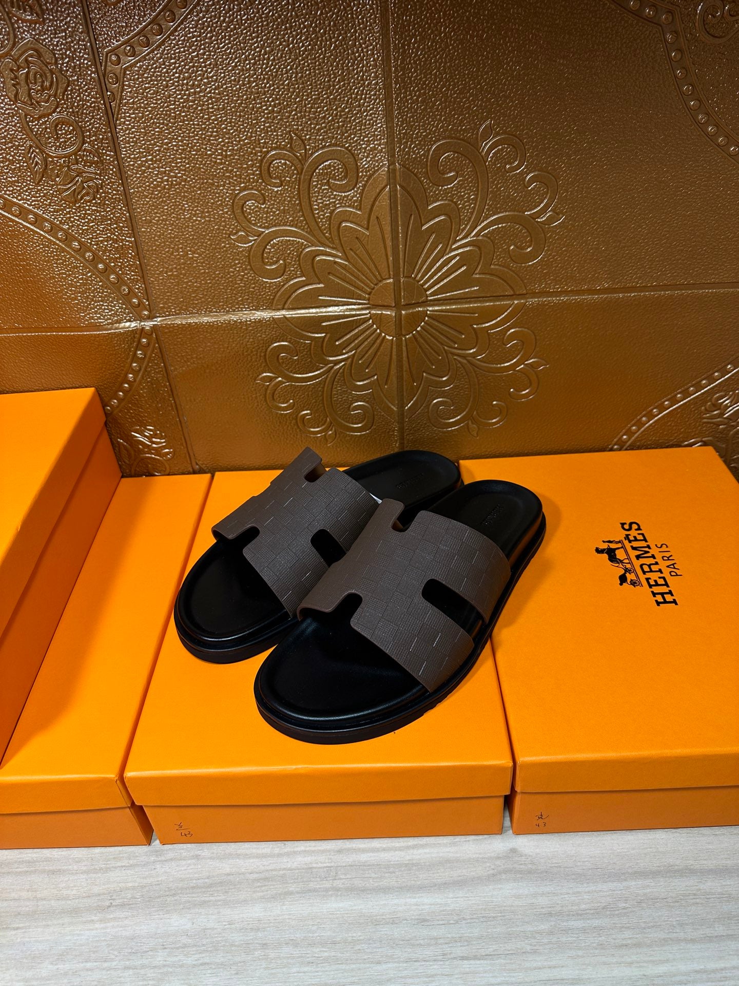 Pair of Hermes slide sandals with dark textured straps and open toe