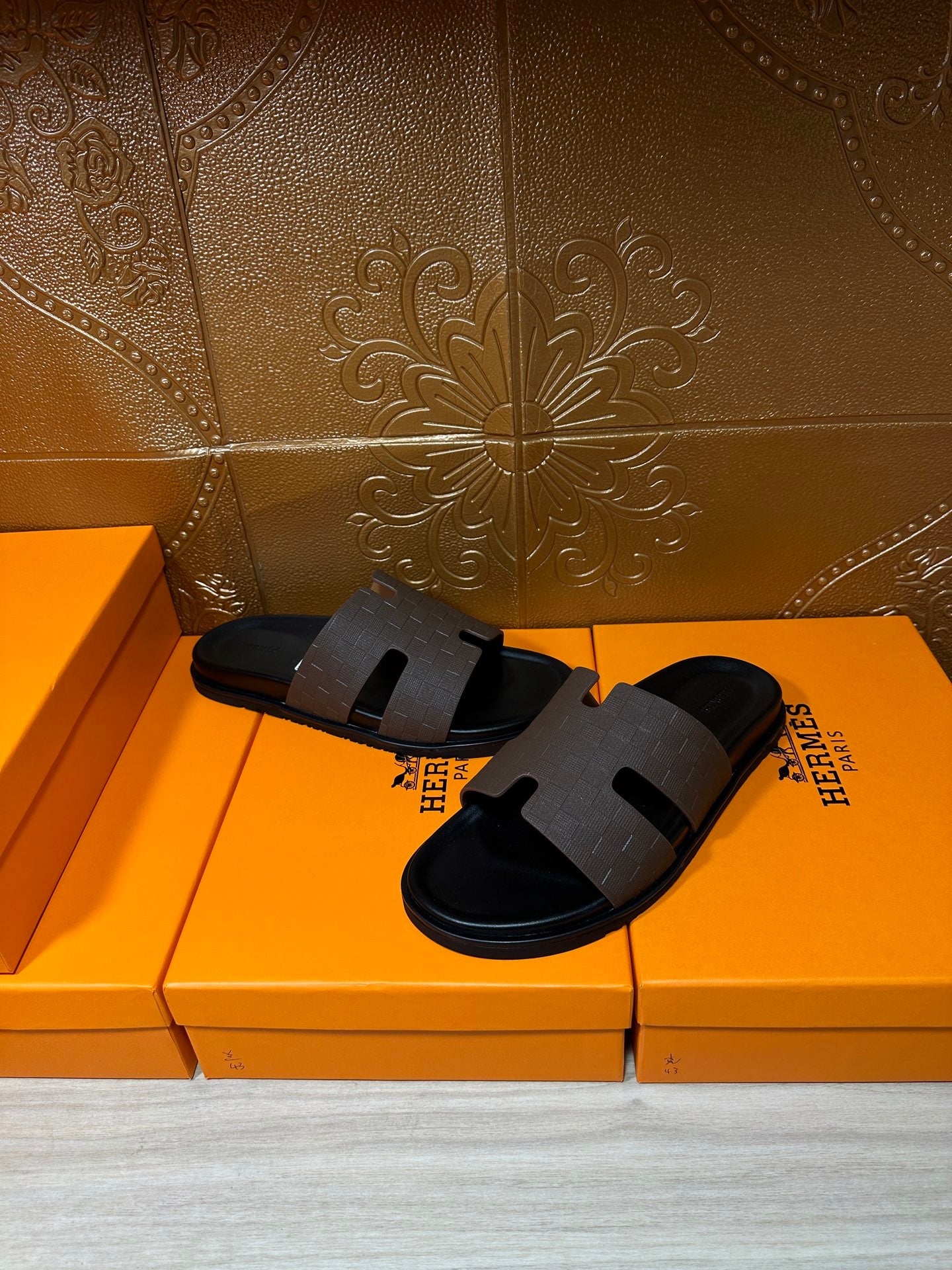 Hermes slide sandals with dark strap across the toes and molded footbed