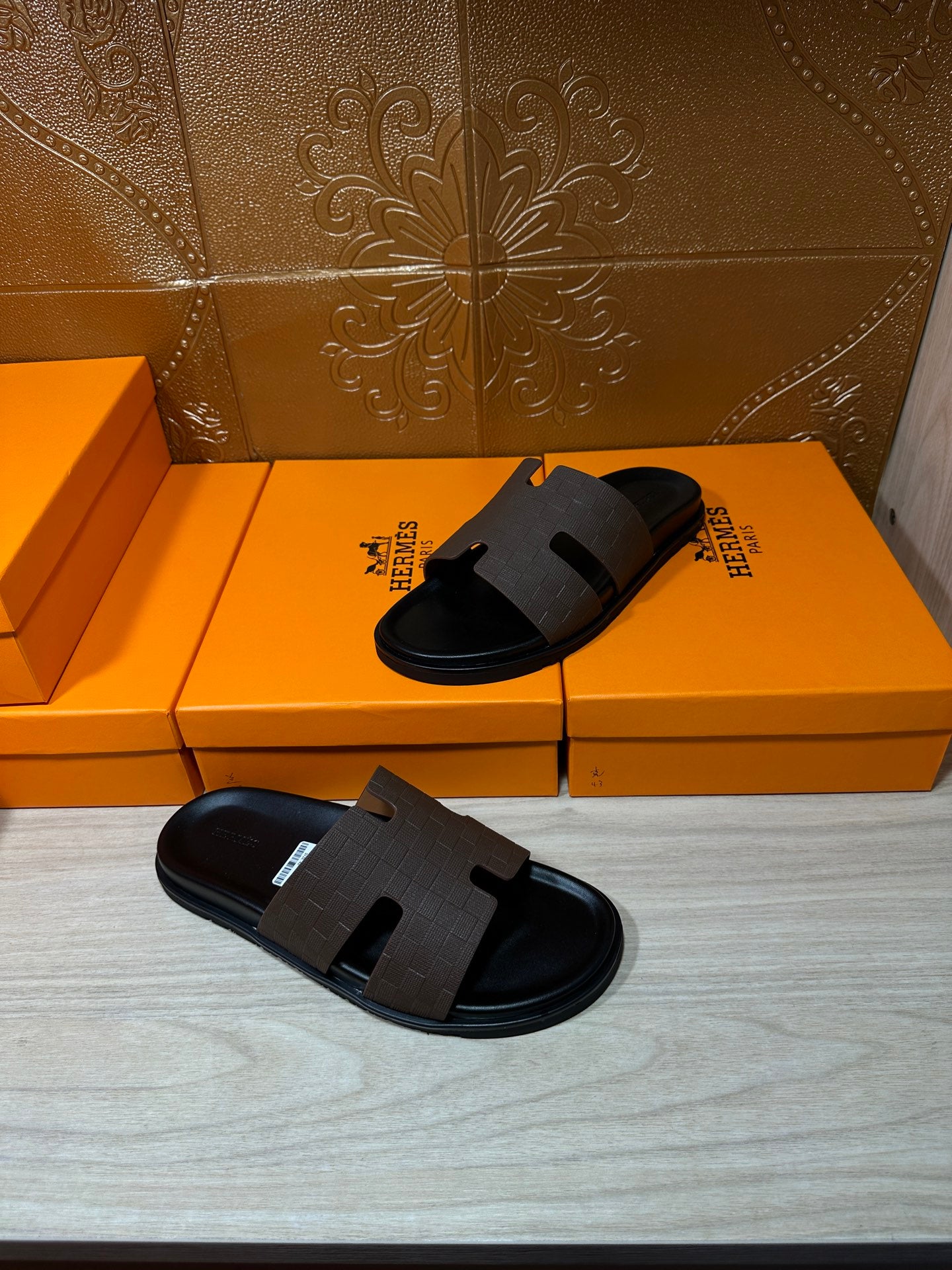 Hermes slide sandals with dark straps and cushioned black footbed, pair