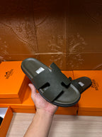 Hermes slide sandal, dark green, one shown in hand with wide strap and footbed