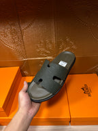 Hermes slide sandal, dark green with embossed strap and footbed, one shown in hand